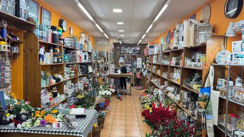 Interior de la tienda Puigbertran, con estanterías de menaje de cocina, tazas y flores