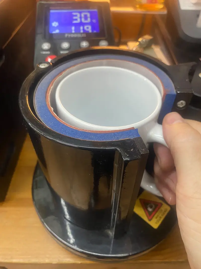 Poniendo la taza en la máquina de sublimación